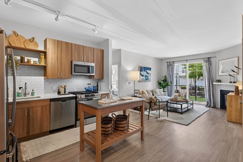 A modern kitchen with wooden cabinets and a dining table.