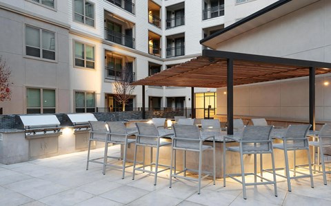 Outdoor Grilling Stations Under Pergola with Granite Dining Counters