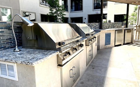 Stainless Steel Barbecue Grills with Tile Backsplash in Outdoor Kitchen