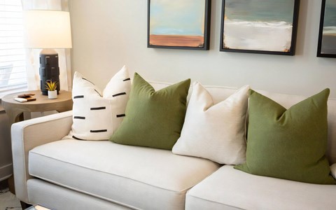 a white couch with green pillows in a living room