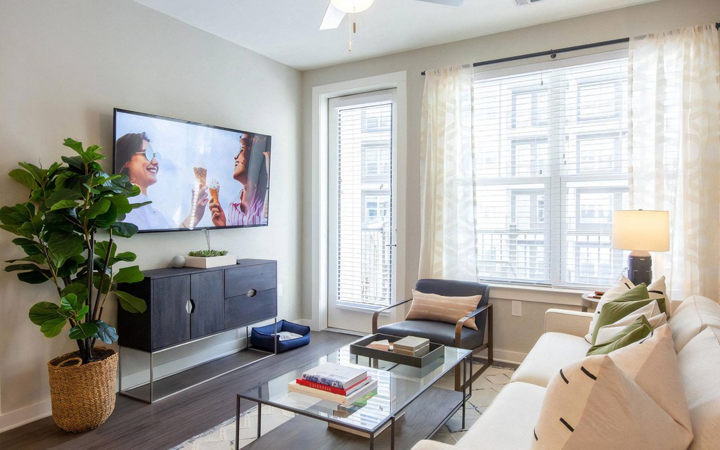 Living Room with Wall-Mounted TV, Coffee Table, and Balcony Access