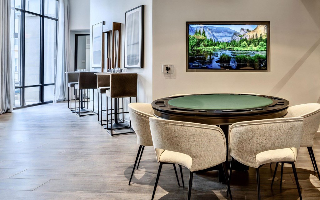 Clubhouse Game Room Featuring Round Poker Table and Upholstered Chairs