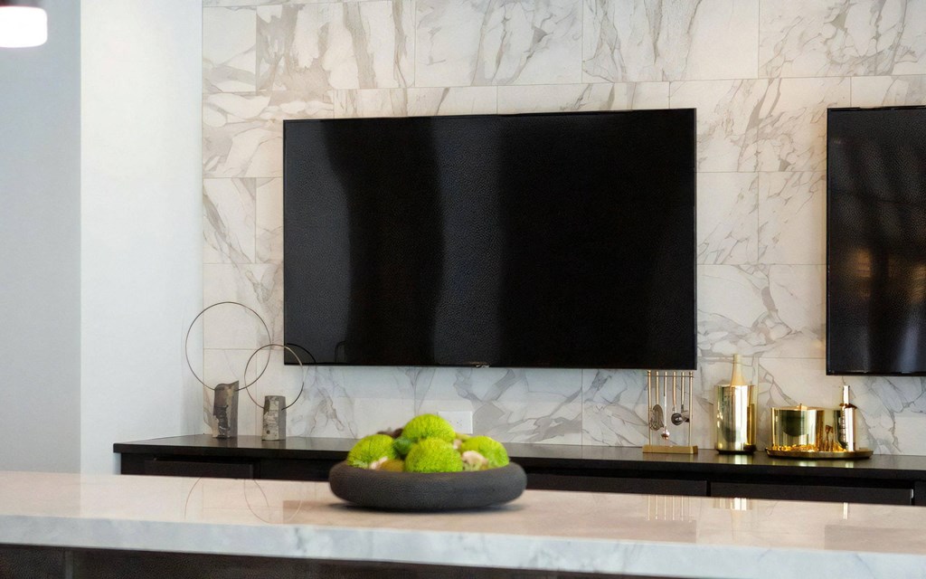 Entertainment Area Featuring Dual TVs, Display Items, and Seating Counter