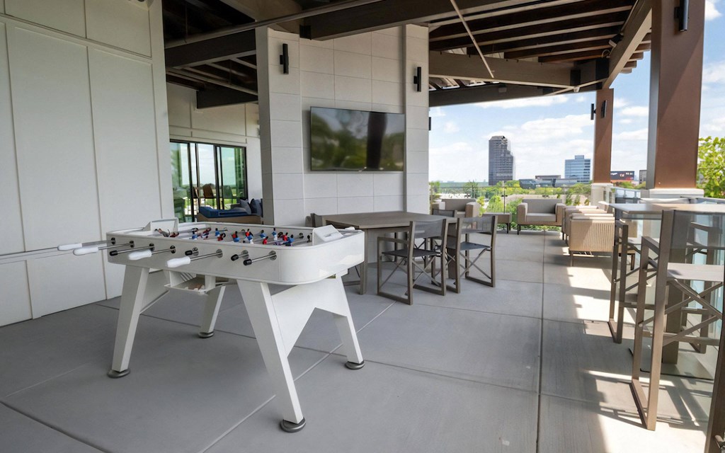 Rooftop Gathering Space with TV, Game Table, and Dining Setup