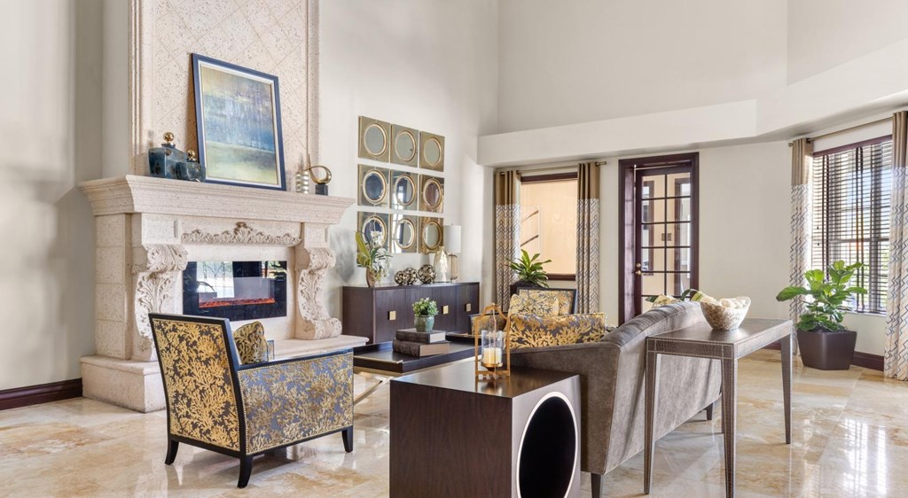 A living room with a fireplace, a chair, a table, and a painting on the wall.