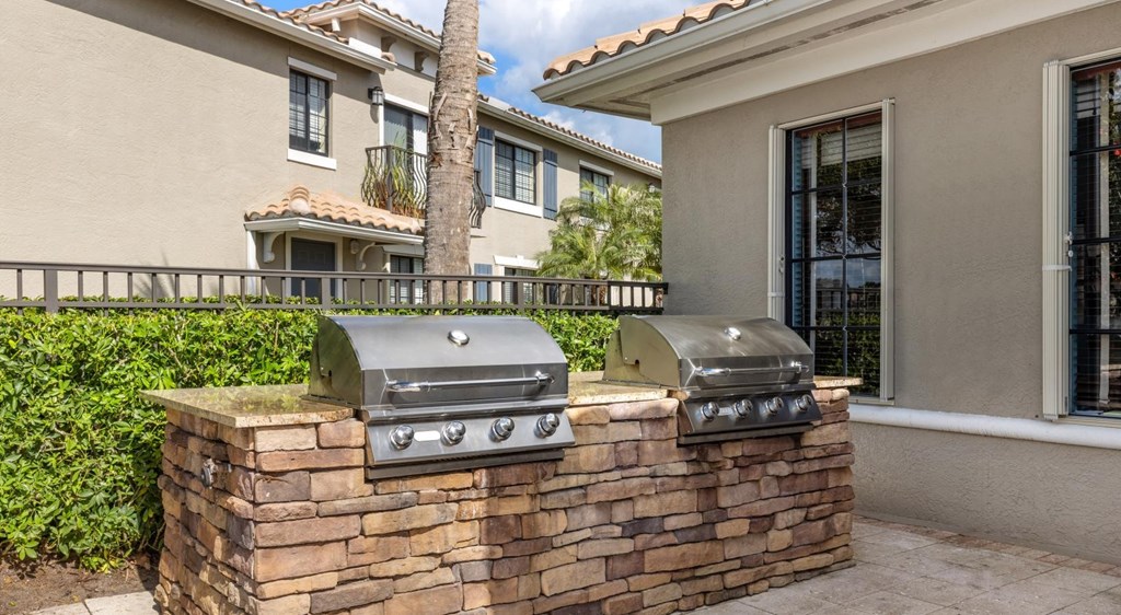 A stone wall with two grills on top.