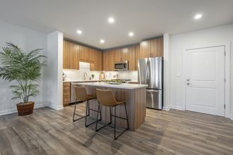 kitchen with island, counter seating, stainless steel appliances and granite countertops - luxury arlington ma apartments