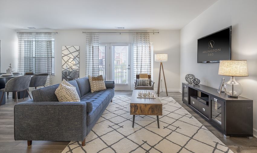 Open floor plan showing living room with sofa, chair, coffee table, tv, console table and a view of the dining room area - arlington ma luxury apartments - Photo Gallery