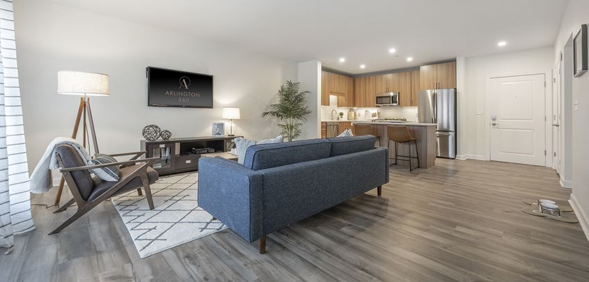 Open floor plan showing living room with sofa, tv, and a view of the kitchen. arlington ma luxury apartments - Photo Gallery