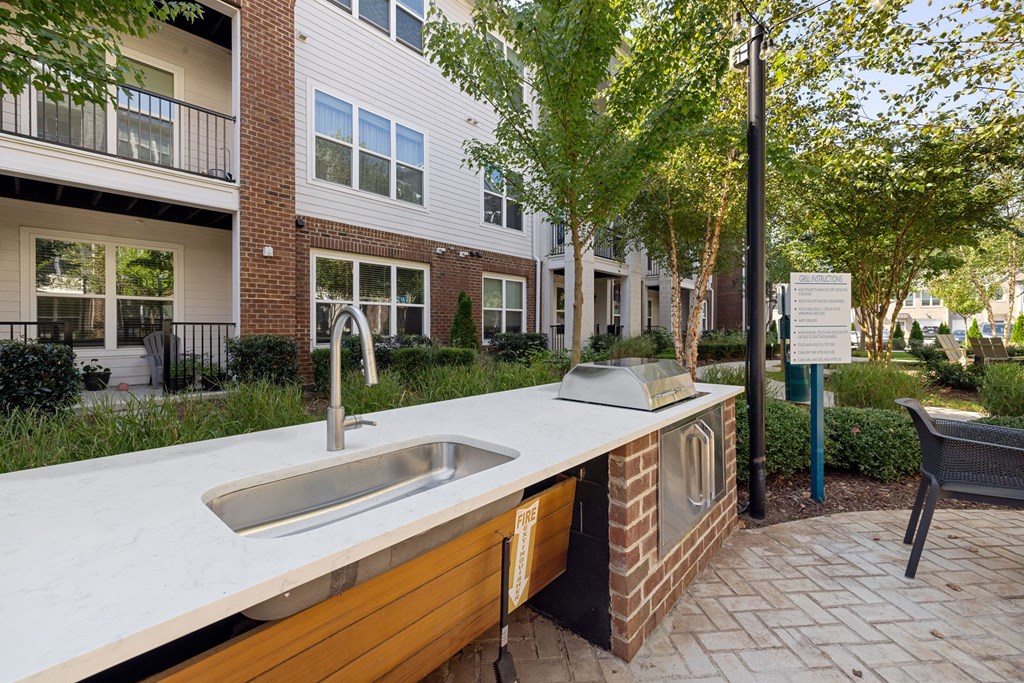 A modern outdoor kitchen with a sink and grill.