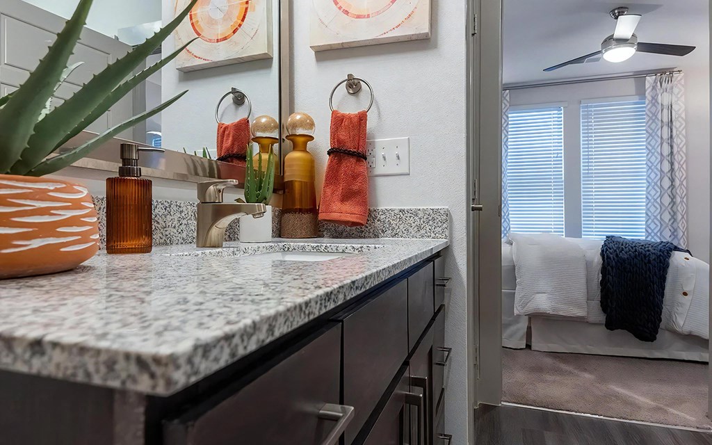 Dual Vanities With Granite Countertops and Bedroom Access