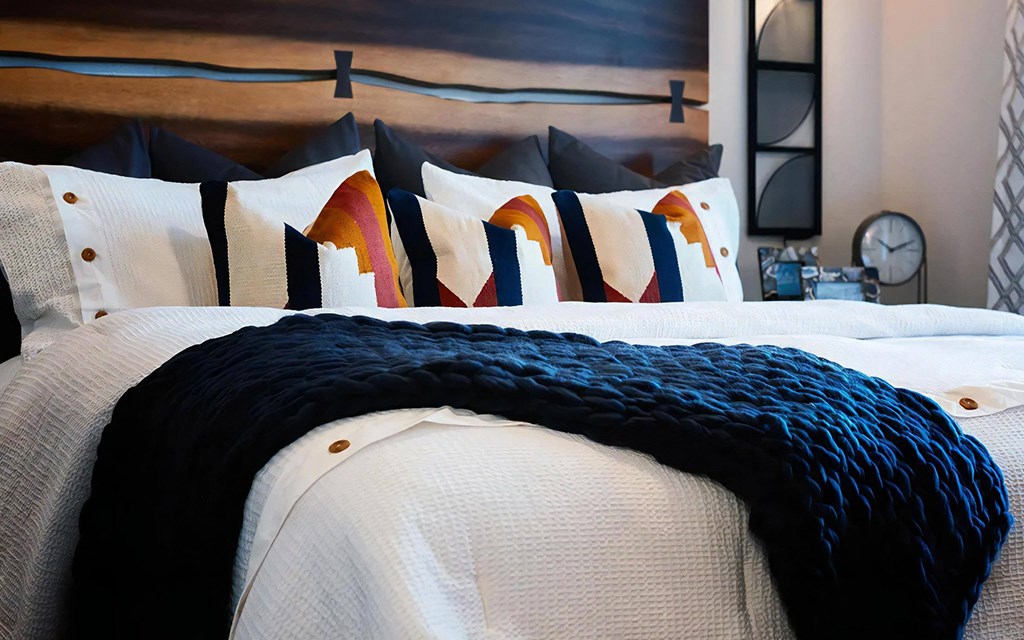 Thoughtfully Designed Bedroom with Colorful Pillows and Custom Wood Headboard