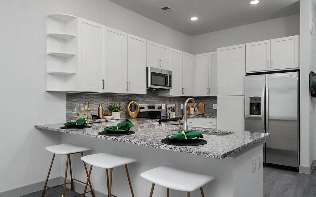 Open Kitchen Layout with White Cabinets and Stainless Steel Appliances