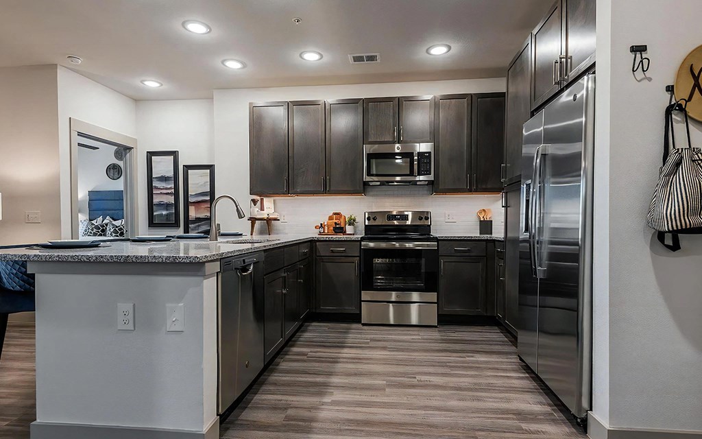 U-Shaped Kitchen with Dark Cabinetry and Granite Countertops