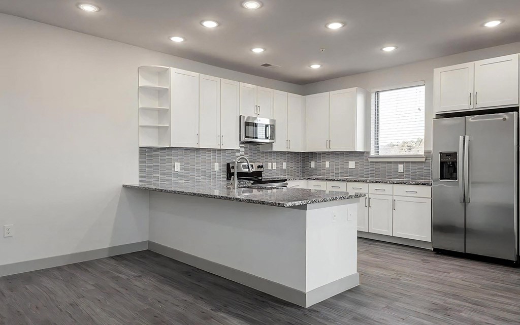 Modern Kitchen with Oversized Granite Breakfast Bar and Ample Storage