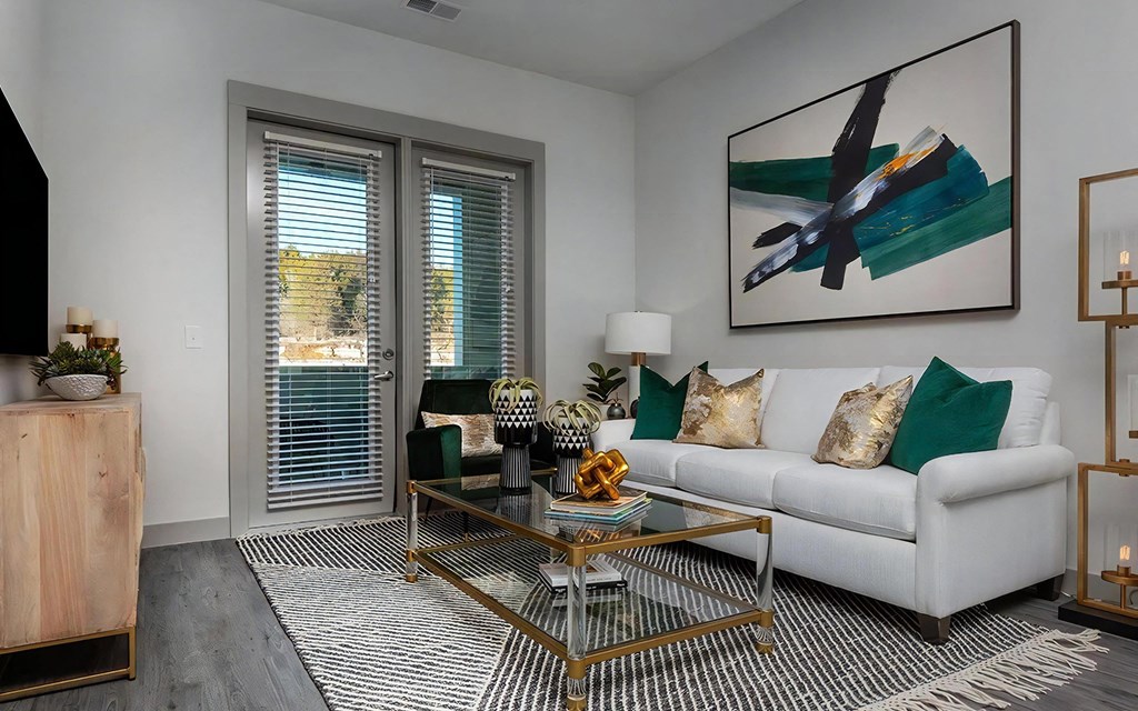 Chic Living Space Featuring White Sofa, Abstract Art, and Glass Coffee Table