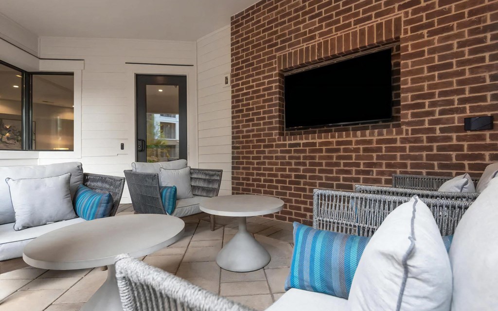 Cozy Outdoor Seating Area with Mounted TV and Modern Furniture