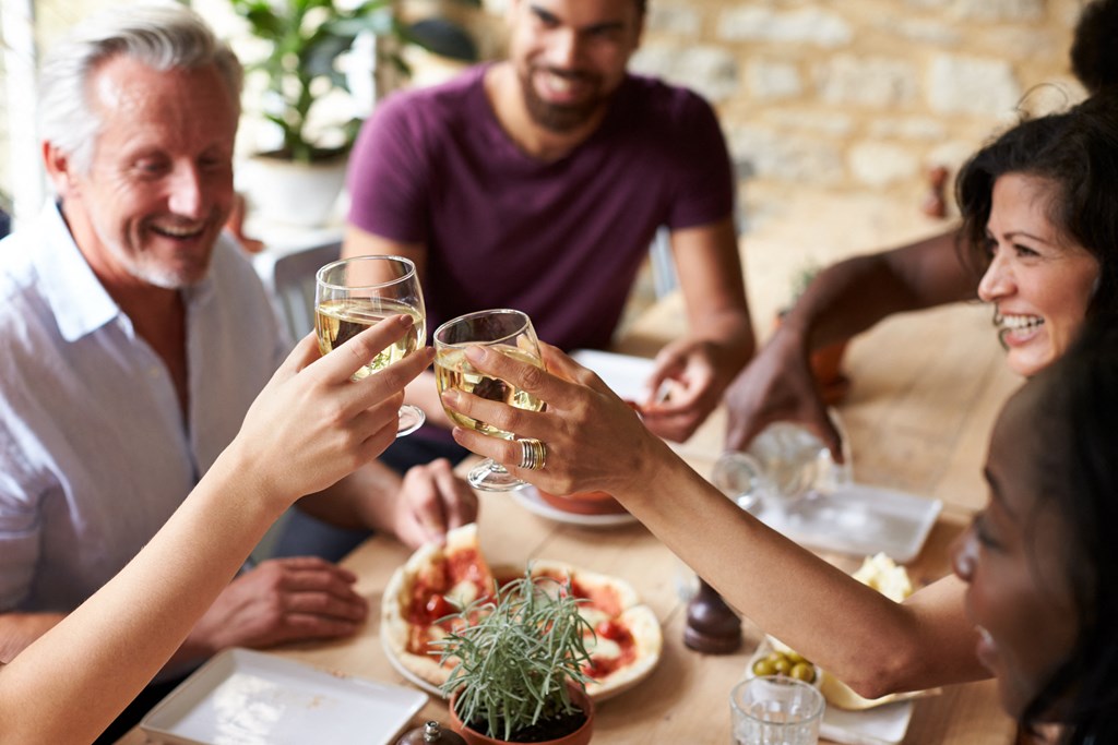 a group of people sitting around a table with wine glasses