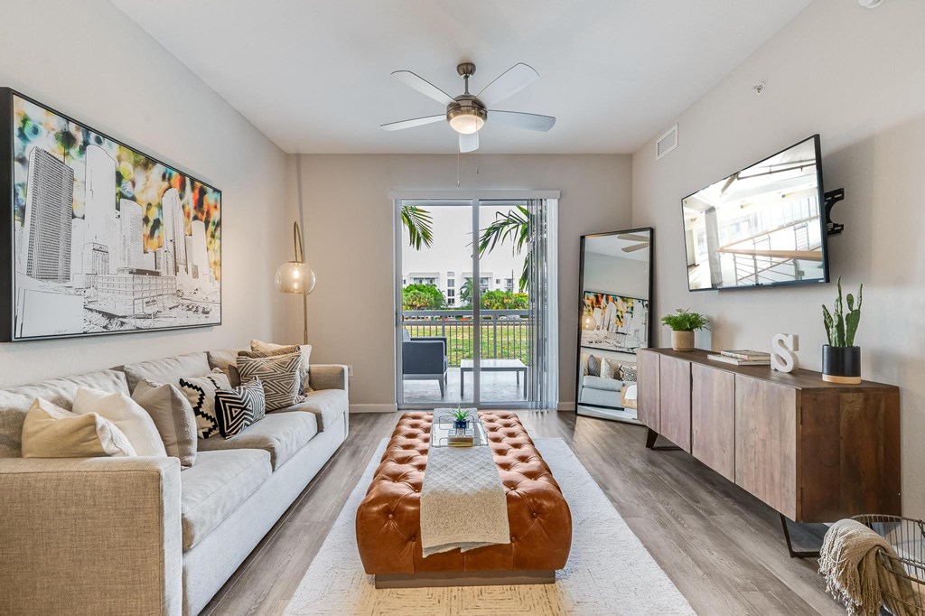 Living Room with Wall-Mounted TV, Balcony View, and Ceiling Fan