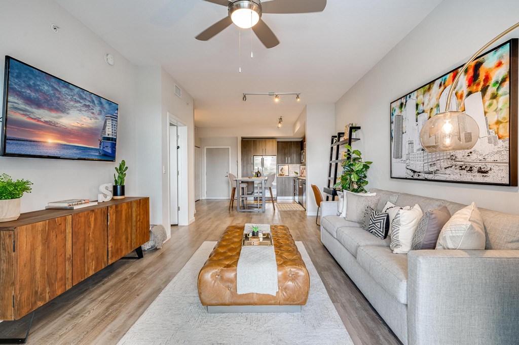 Living Room with Wall-Mounted TV and Entry to Kitchen and Dining Space
