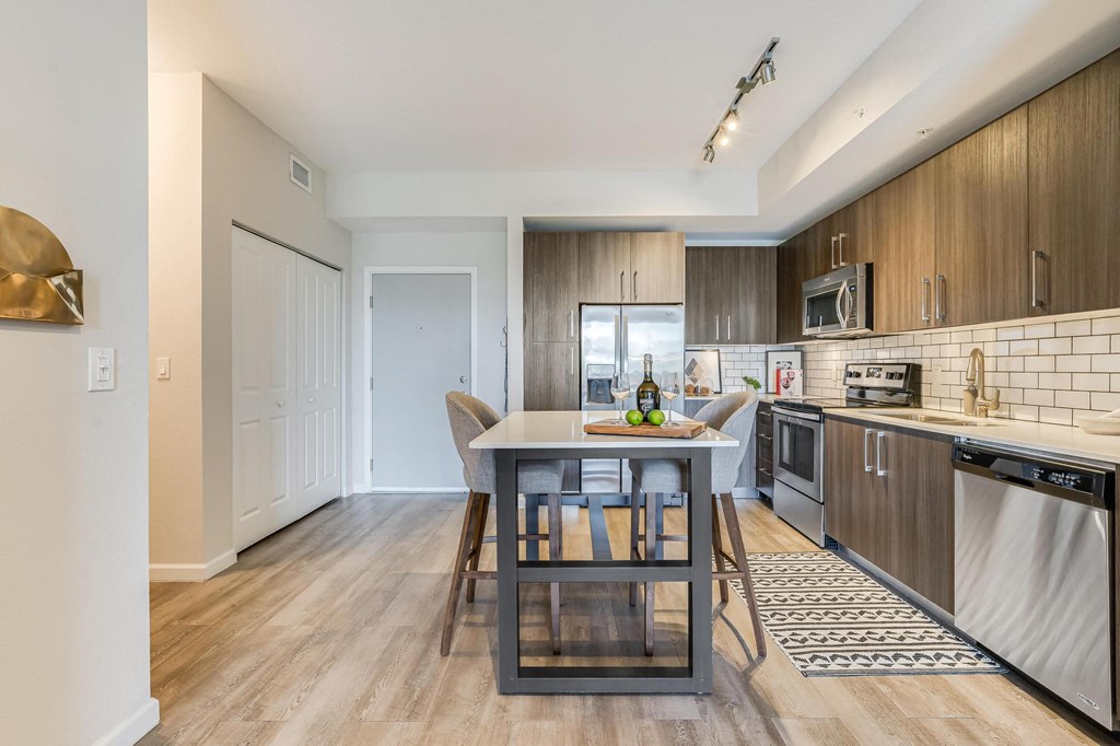 Full Kitchen with Dining Island, Stainless Steel Appliances, and Tile Backsplash