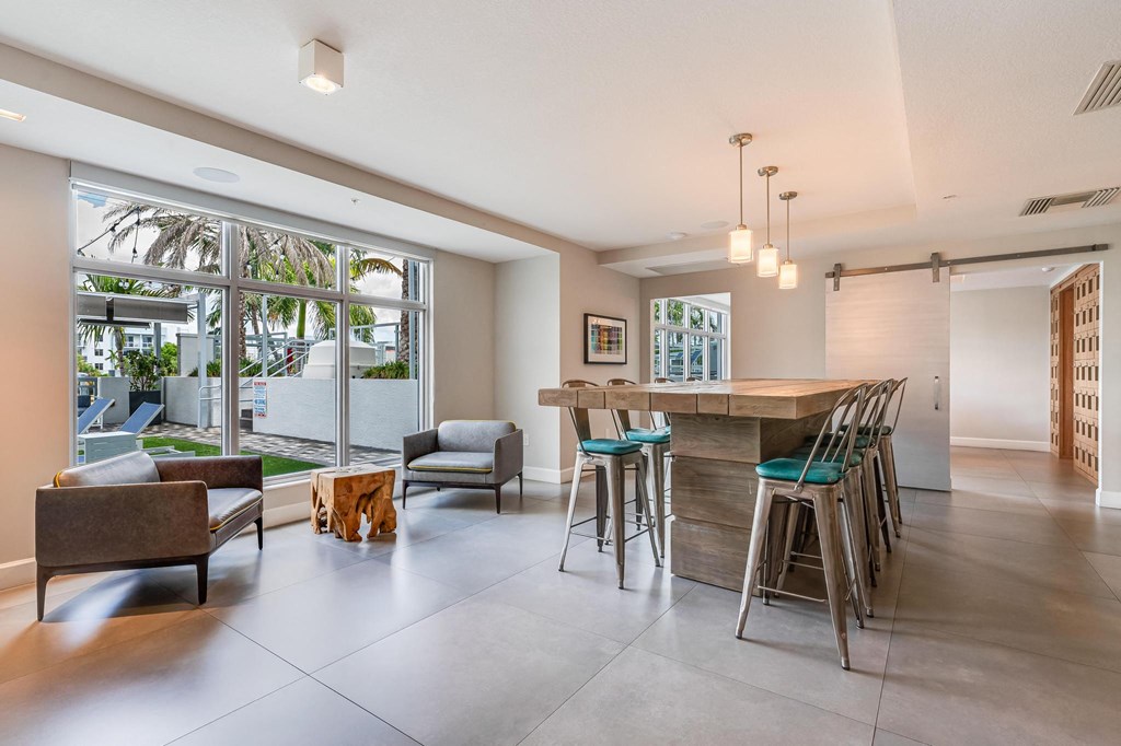 Clubroom with Community Table, Lounge Chairs, and Window Views