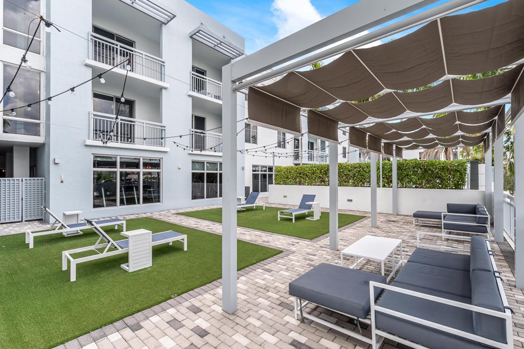Ground-Level Green Space with Lounge Chairs and Walkways Next to Residential Windows