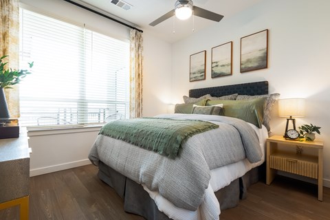 A bedroom with a large bed and a ceiling fan.