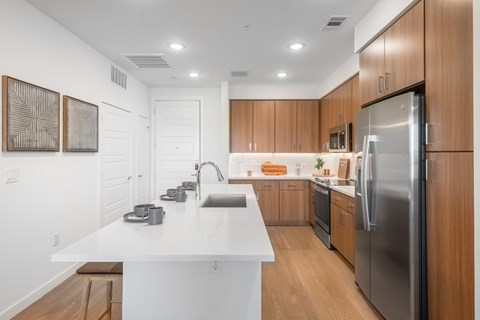A modern kitchen with wooden cabinets and stainless steel appliances.