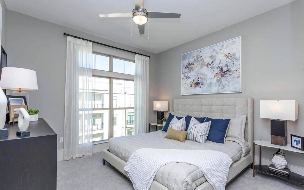 Apartment Bedroom with Upholstered Bed, Large Window and Ceiling Fan