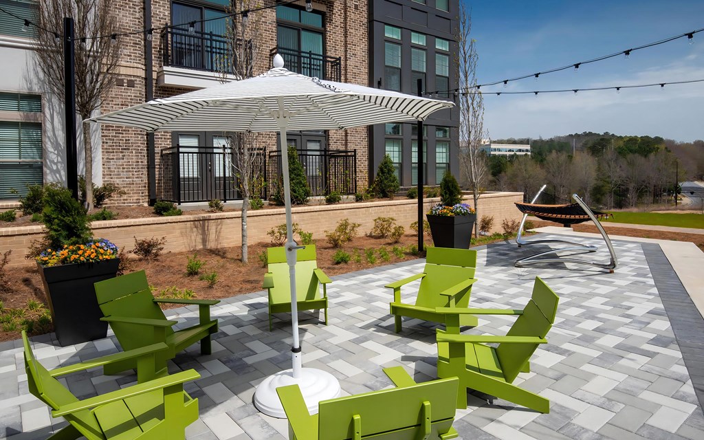 Courtyard Deck with Lounge Chairs and Greenery Near Apartment Building