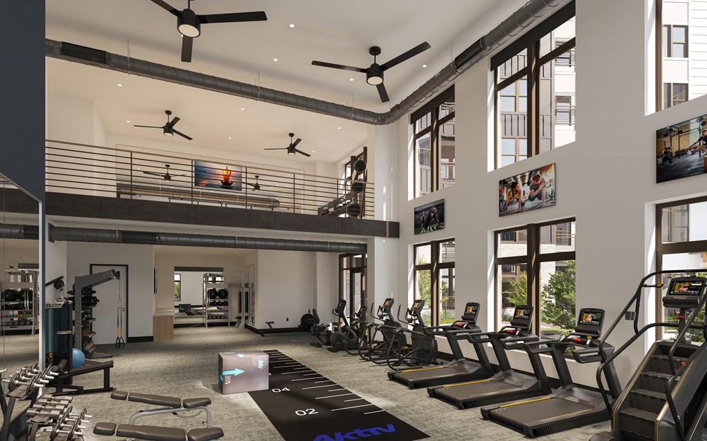 a gym with treadmills and weights in the lobby of a building