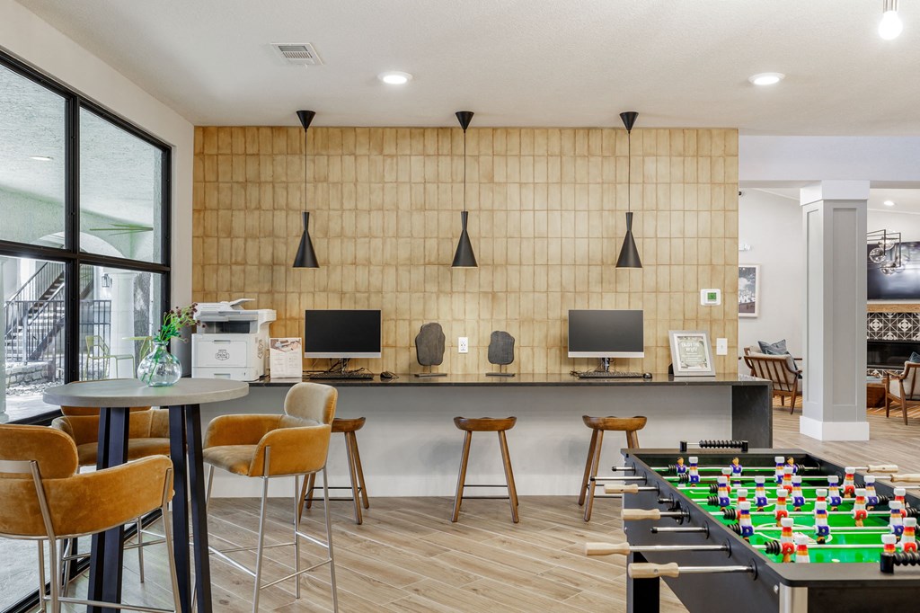 a games room with a foosball table and computer monitors