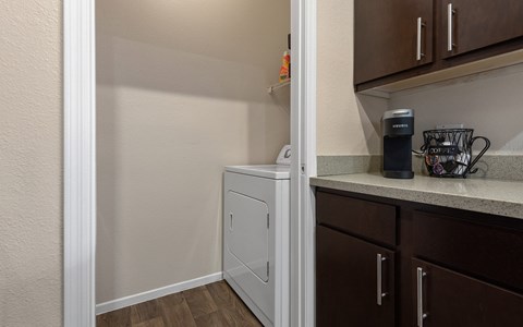 a kitchen with a washer and dryer and a counter with a coffee maker