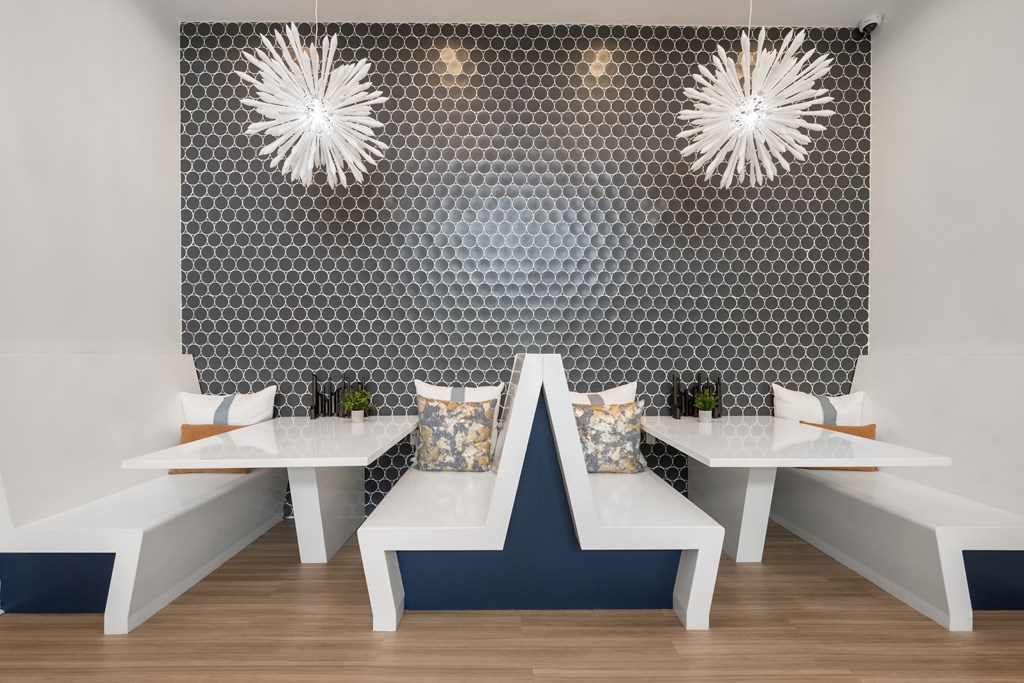 A dining area with a white table and bench against a patterned wall.