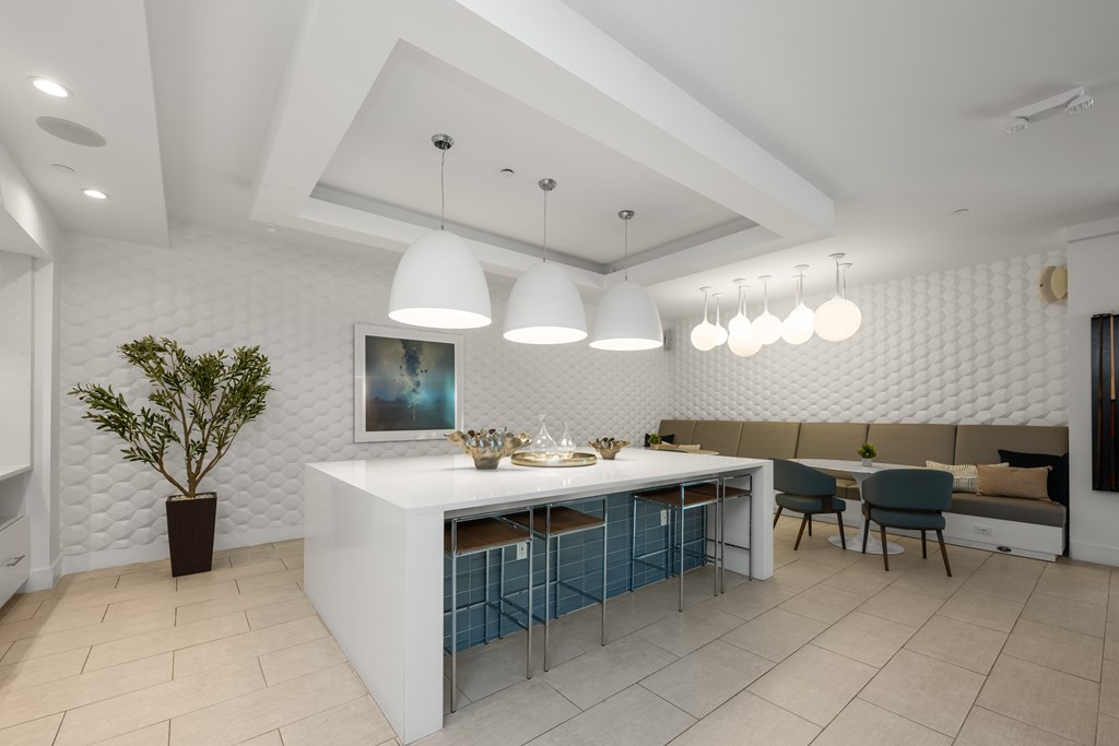 A modern kitchen with a white counter and blue tiles.