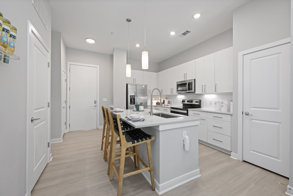 A kitchen with a table and chairs in the middle.