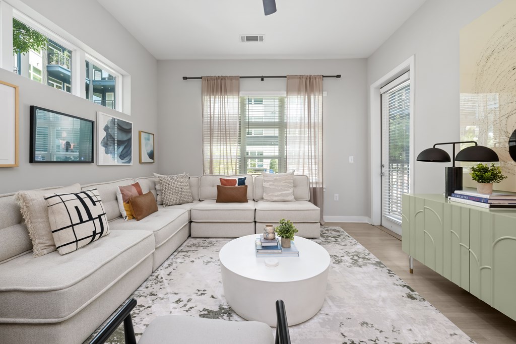 A living room with a white couch, a coffee table, and a rug.