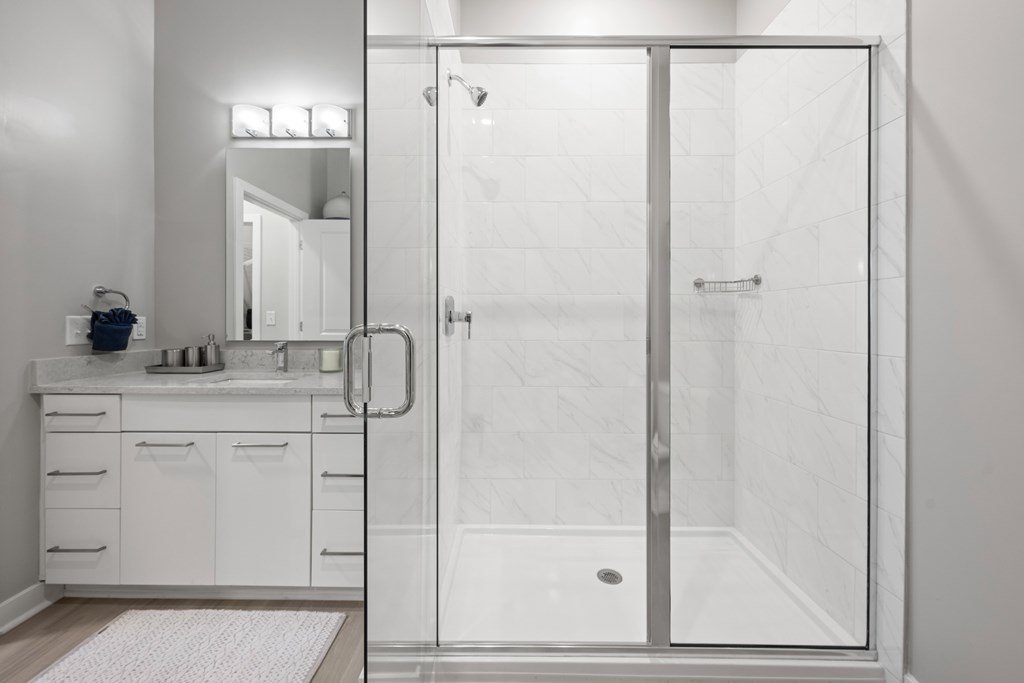 A white bathroom with a walk in shower.