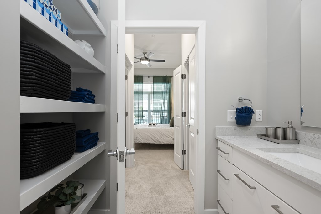 A bathroom with a white vanity and a white ceiling fan.