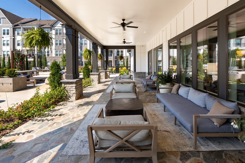 a patio with couches and chairs and a ceiling fan