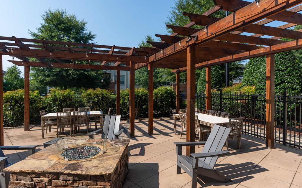 Outdoor Entertainment Area with Fire Pit and Dining Tables Under Pergola