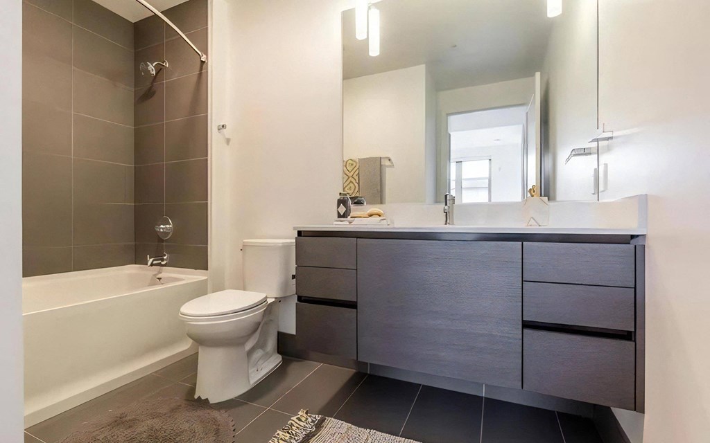 Apartment Bathroom with Tub, Large Mirror, and Dual Sink Vanity
