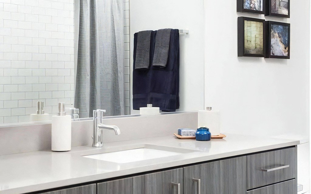 Vanity Area with Undermount Sink, Tile Wall, and Framed Artwork