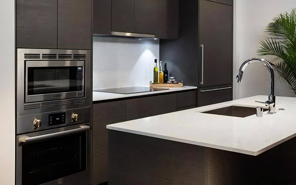 Apartment Kitchen with Stainless Steel Appliances and Black Tile Backsplash