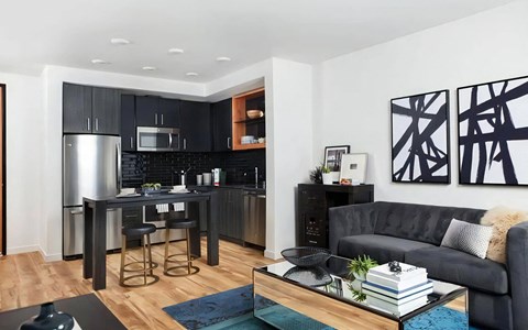 a living room with a couch and a kitchen with a bar