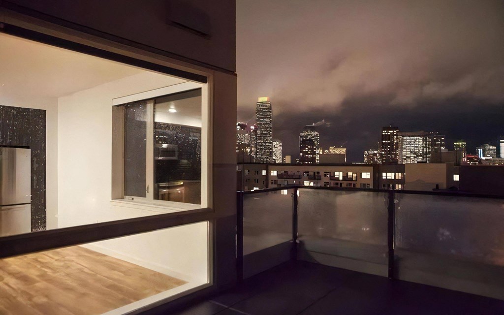 Nighttime Apartment View with Lit Buildings and Skyline in Background