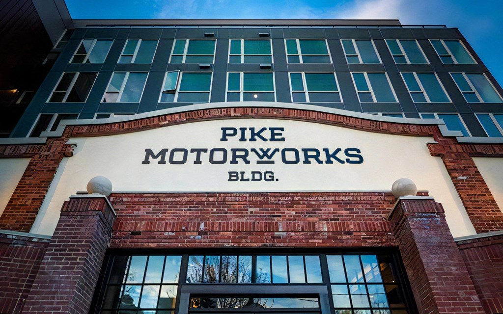 Exterior View of Pike Motorworks Entrance with Signage and Upper Windows