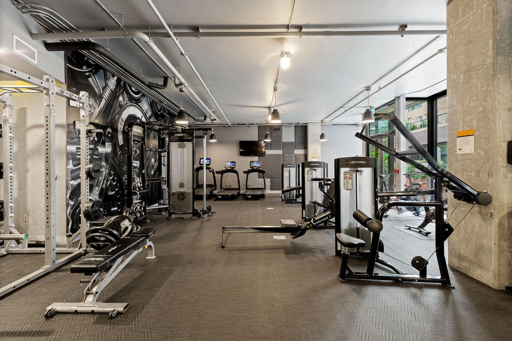 A gym with a variety of equipment including a leg press machine.