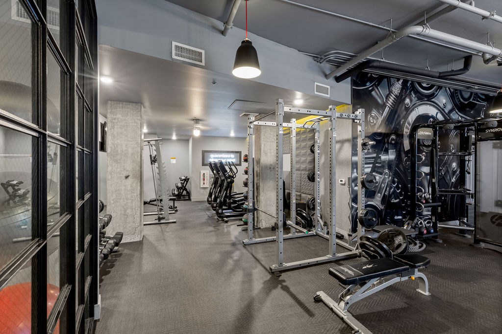 A gym with a variety of equipment including weights and weight machines.